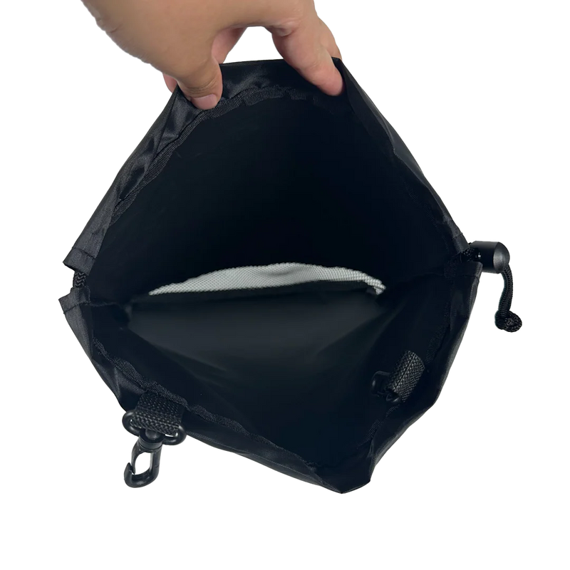 Black bag with a hand holding it open on a white background