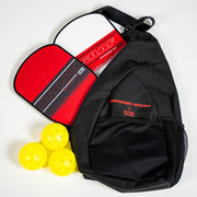 Black bag with red paddle and yellow balls on a white background