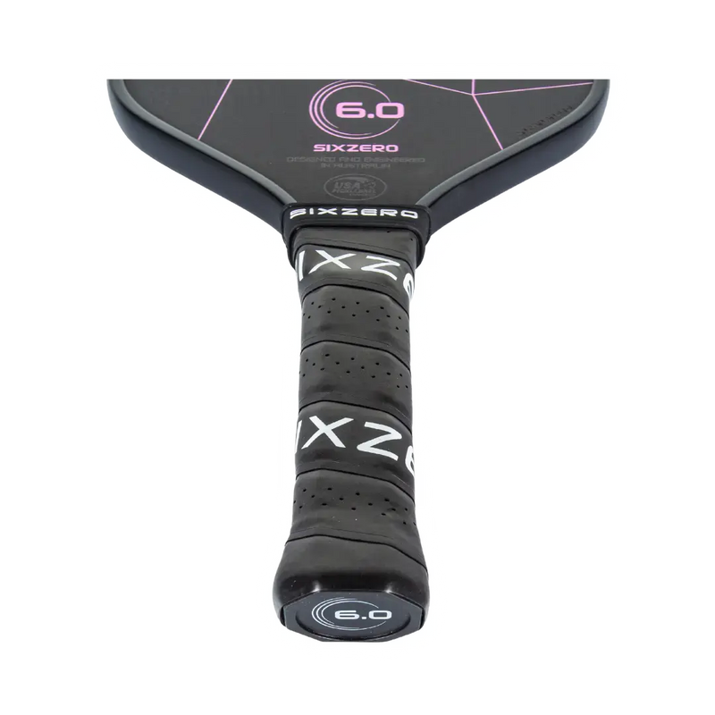 Close-up of a SixZero pickleball paddle with branding and model number on a white background