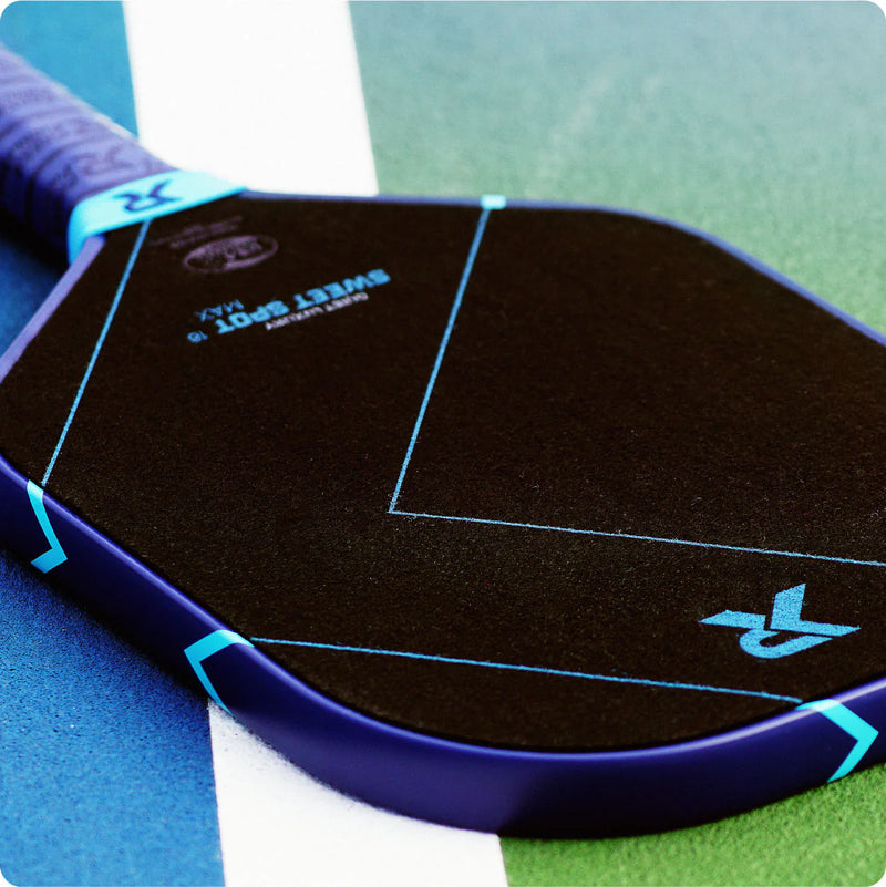 Close-up of a pickleball paddle with 'Sweet Spot' branding on a multicolored court background.