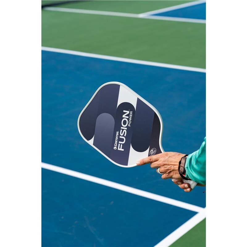 Person holding a Fusion pickleball paddle on a court