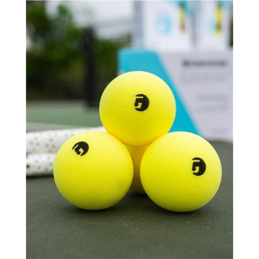 Three yellow tennis balls with a brand logo on a tennis court.