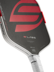 Close-up of a pickleball paddle with visible branding on a white background