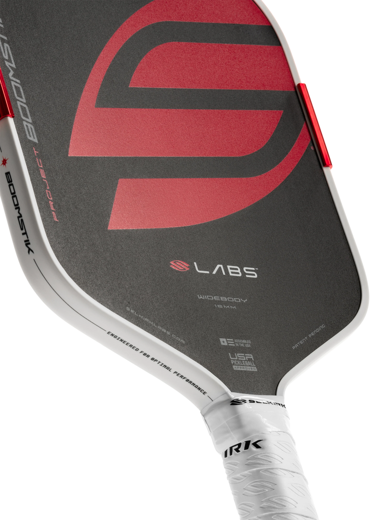 Close-up of a pickleball paddle with visible branding on a white background