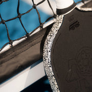 Close-up of a black and white sports pad with branding against a blurred background