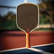 LOCO pickleball paddle on a court with blurred background