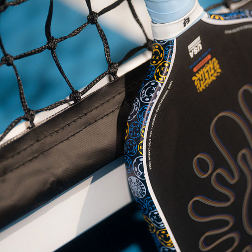Close-up of a paddle with branding against a blue background