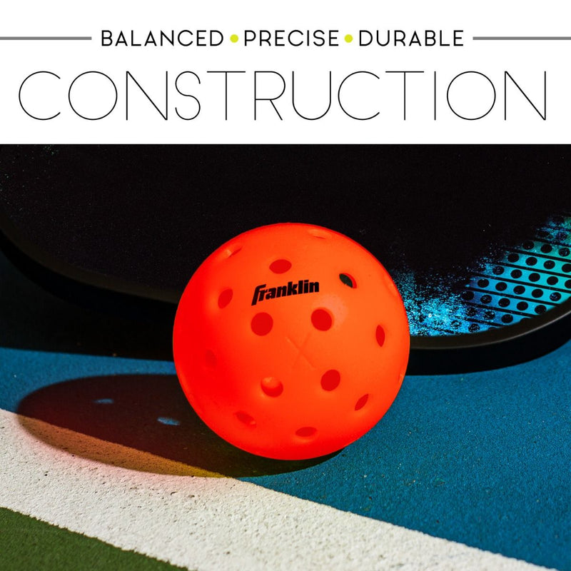 Orange pickleball on a blue and green surface with Franklin branding