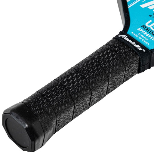 Close-up of a black textured pickleball paddle grip with a brand label.