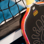 Close-up of a paddle with colorful design against a blue background