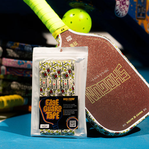 Pickleball paddle with Edge Guard Tape packaging on a blue surface