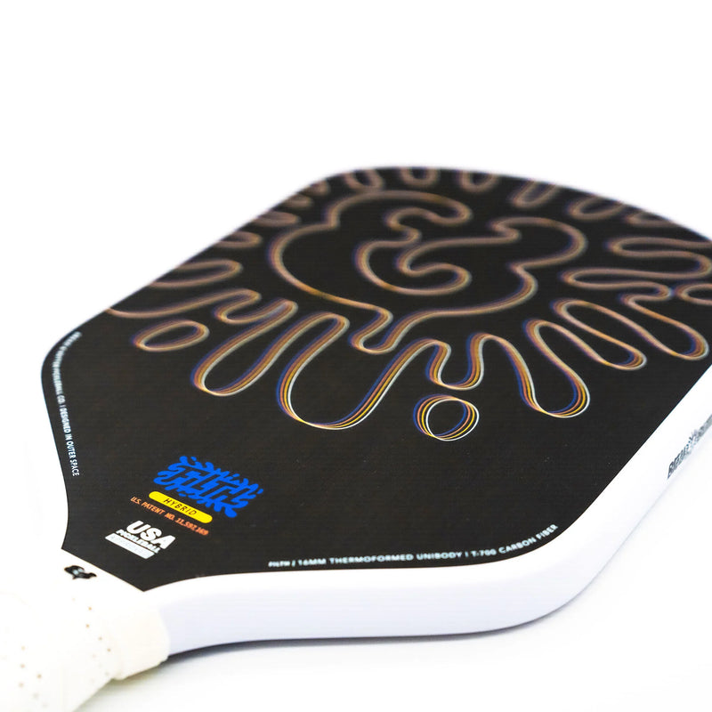 Close-up of a paddle with a black and gold design on a white background