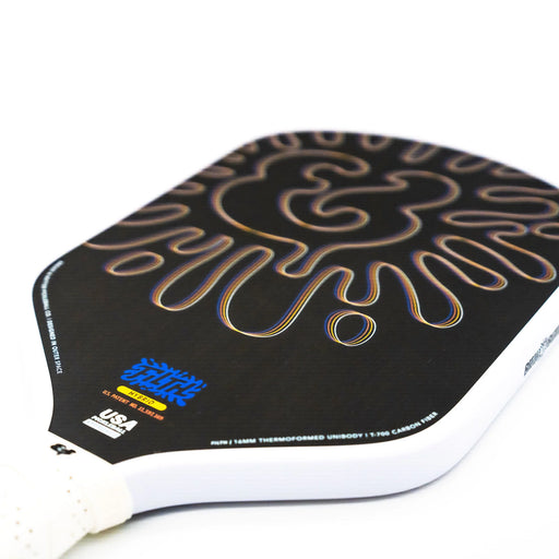 Close-up of a paddle with a black and gold design on a white background