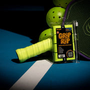 Grip tape with 'Grip Rip' packaging on a tennis racket handle against a dark background