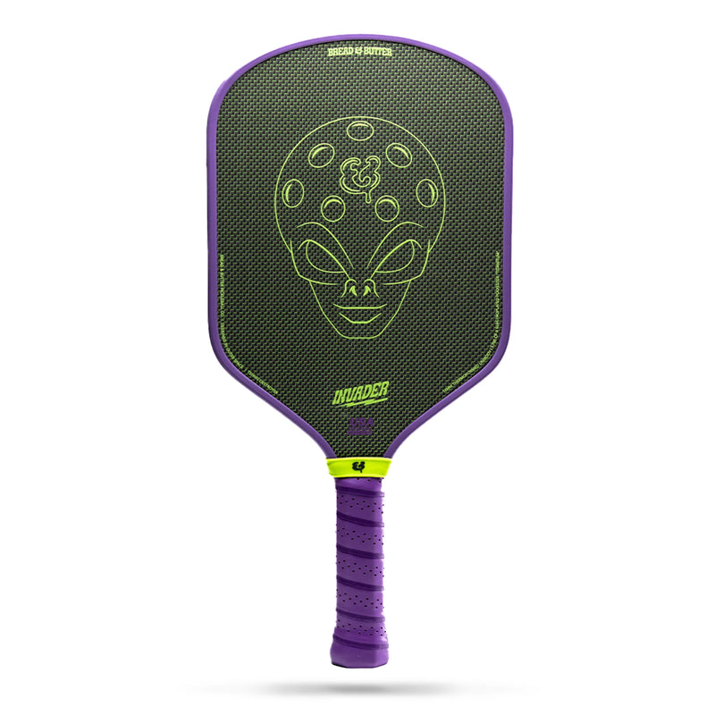 Purple pickleball paddle with green alien design on a white background