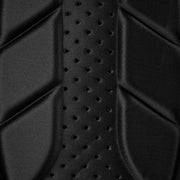 Close-up of a black textured surface with a pattern of small holes.