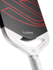 Close-up of a Luxx paddle with a white handle and black face with red accents on a white background.