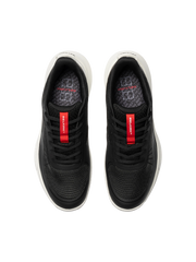Black athletic shoes with red accents on a white background