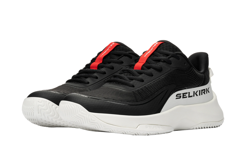 Black and white sneakers with red accents on a white background