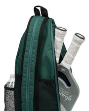 Green backpack with pickleball paddle and ball inside on a white background
