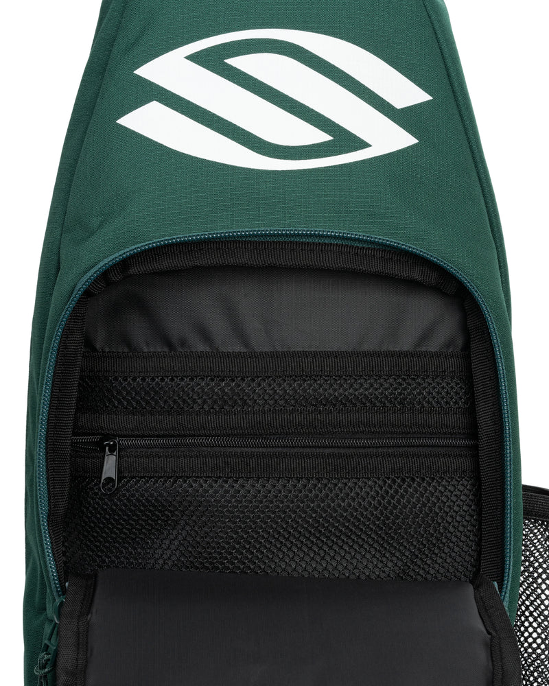 Green backpack with a logo on the top and open front compartment showing black interior.