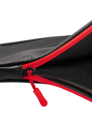 Close-up of a black leather bag with a red zipper on a white background